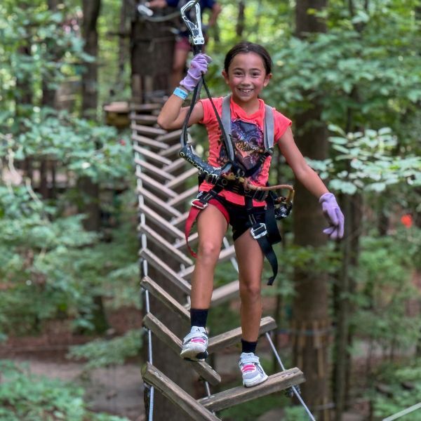 Girl on ropes course bridge